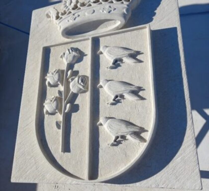 el escudo de piedra municipal, con corona.