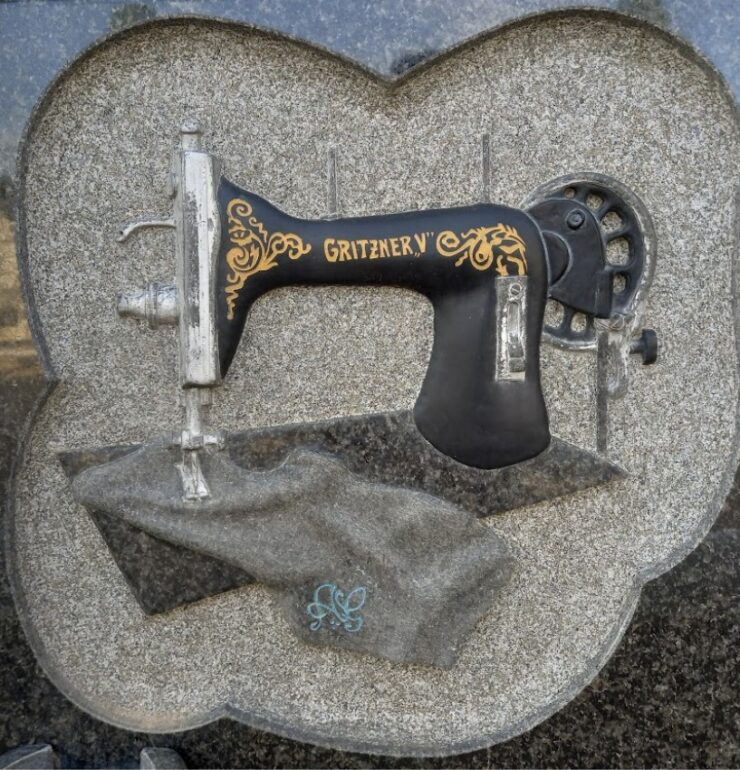 lápida con talla de máquina de coser y tela. Se trata de una de nuestras lápidas más artísticas.